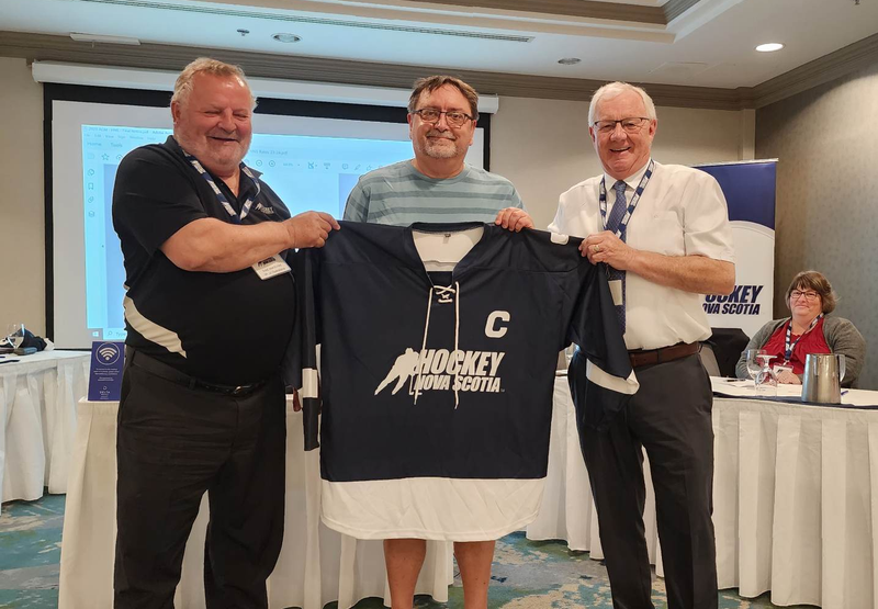 Brian Wentzell receives a Hockey Nova Scotia sweater from Arnie Farrell and Brad MacKinley.